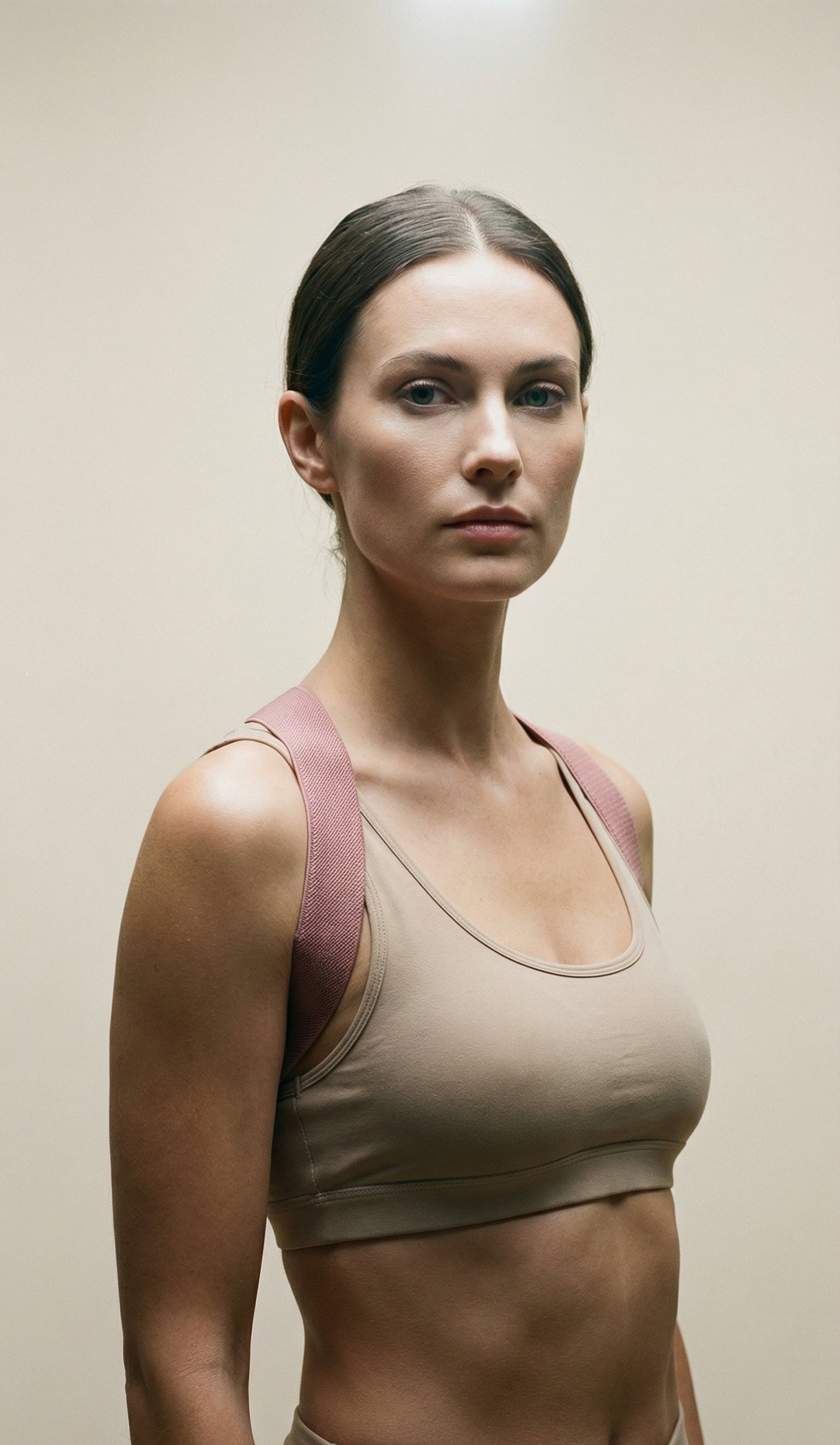 Woman wearing a beige sports bra against a plain background