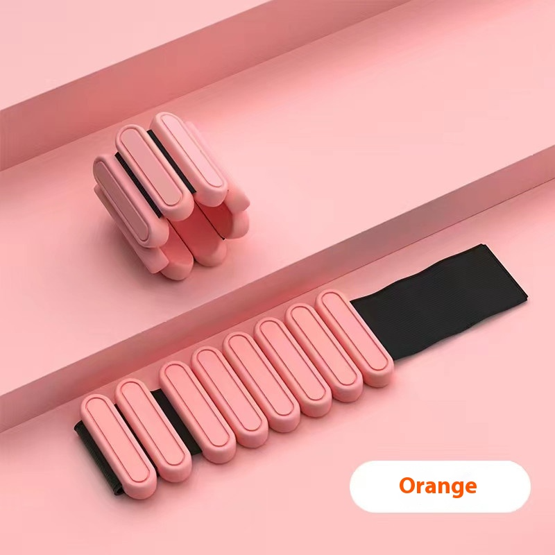 Orange weighted bracelet on a gray surface with 'Orange' label