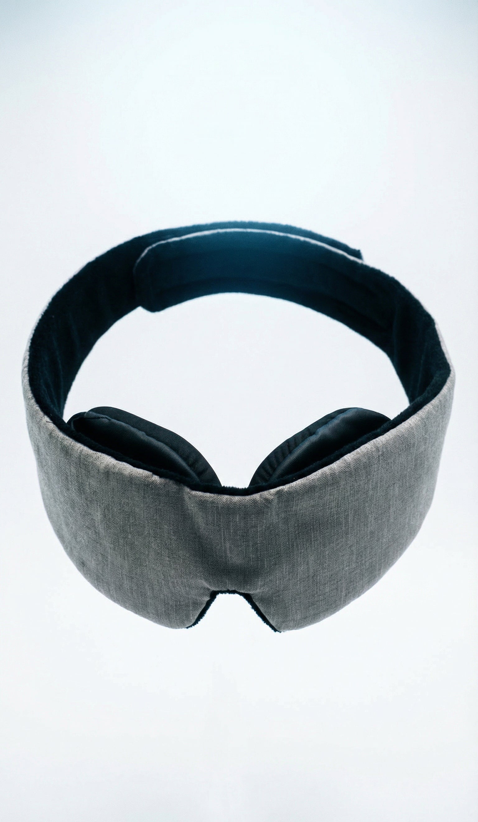 Gray sleep mask with black ear covers on a white background